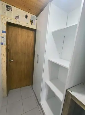 a walk in closet with a wooden door and shelves at Cabaña Rincón de Afrodita in San Lorenzo