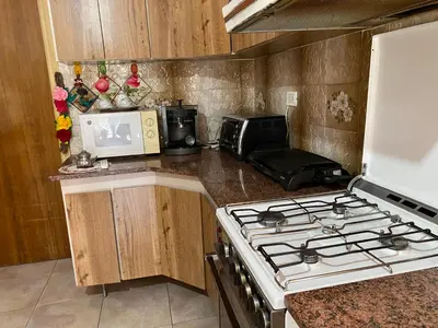 a kitchen with a stove and a microwave at CASA SAN PABLO CENTRO (sólo familias) in Villa Carlos Paz