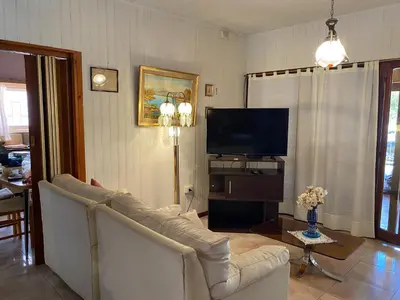 a living room with a couch and a flat screen tv at CASA SAN PABLO CENTRO (sólo familias) in Villa Carlos Paz
