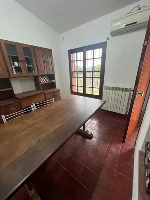 a kitchen with a wooden table in a room at Chalet Mariam in Villa Carlos Paz