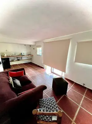 a living room with a couch and a table at Hospedaje Frente al Rio Dos Soles in Santa Rosa de Calamuchita