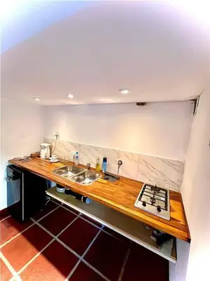 a kitchen with a sink and a counter top at Hospedaje Frente al Rio Dos Soles in Santa Rosa de Calamuchita