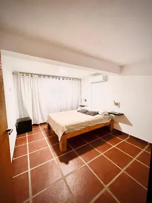 a bedroom with a bed in a room at Hospedaje Frente al Rio Dos Soles in Santa Rosa de Calamuchita