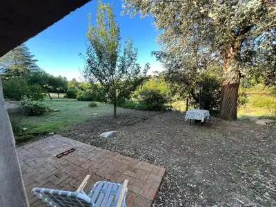 two blue chairs and a bench in a yard at Hospedaje Frente al Rio Dos Soles in Santa Rosa de Calamuchita