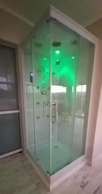 a glass shower stall in a room with at AYRES SUITE in Villa Carlos Paz