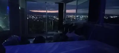 a person sitting in a dark room looking out a window at AYRES SUITE in Villa Carlos Paz