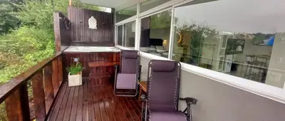 a balcony with two chairs on a wooden deck at AYRES SUITE in Villa Carlos Paz