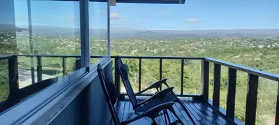 two chairs sitting on a balcony with a view at AYRES SUITE in Villa Carlos Paz