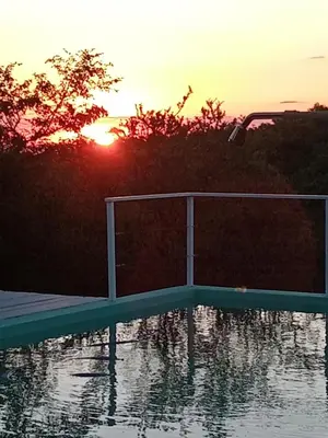 a swimming pool with the sunset in the background at Orquídeas in Quebrada de los Pozos