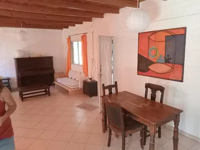 a dining room with a table and a piano at Orquídeas in Quebrada de los Pozos