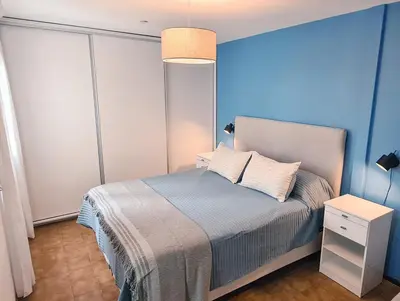 a bedroom with a bed with a blue wall at Casa Nómada - Centro in Cordoba