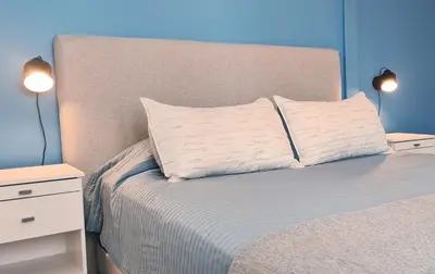 a bed with two nightstands and a pillow on it at Casa Nómada - Centro in Cordoba