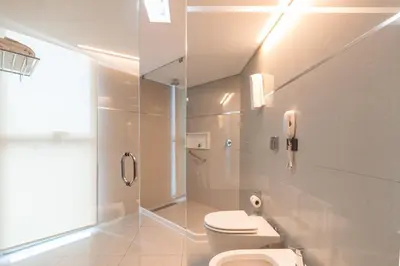 a white bathroom with a toilet and a shower at Yrigoyen 111 Hotel in Cordoba