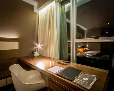 a desk with a laptop on it with a window at Yrigoyen 111 Hotel in Cordoba
