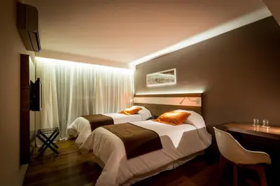 a hotel room with two beds and a desk at Yrigoyen 111 Hotel in Cordoba