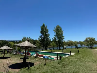 a swimming pool with tables and umbrellas in a park at Cabaña Clarita La Florida in La Florida