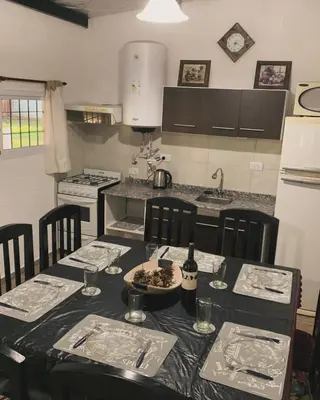 a kitchen with a table with chairs and a counter top at Cabaña Clarita La Florida in La Florida