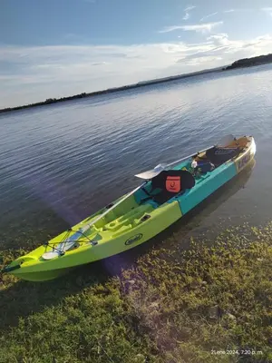 a yellow and blue kayak sitting on the water at Casa Frente Dique Piedras Moras in Almafuerte