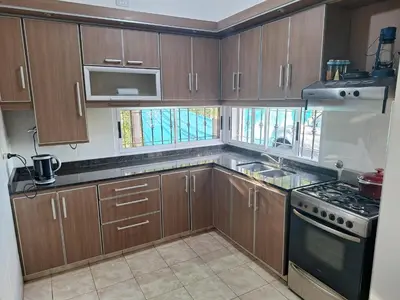 a kitchen with wooden cabinets and a stove top oven at Casa Frente Dique Piedras Moras in Almafuerte