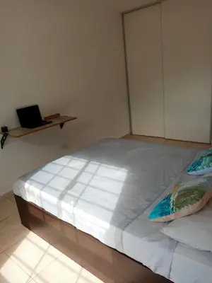 a large bed in a room with a laptop on a shelf at Habitación Colon in Cordoba