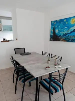 a dining room table with chairs and a painting on the wall at Habitación Colon in Cordoba