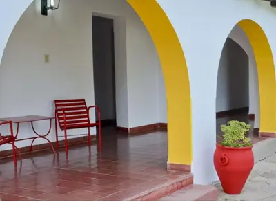 a room with a table and chairs and a vase with a plant at Hotel Agüero in Mina Clavero