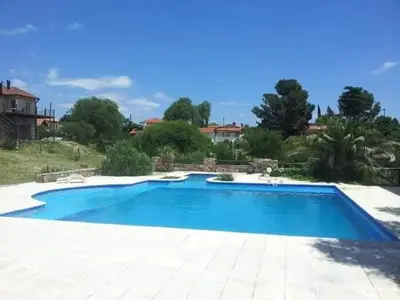 a large blue swimming pool in a yard at Hotel Agüero in Mina Clavero