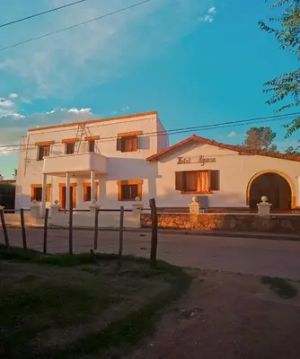 a white building with a fence in front of it at Hotel Agüero in Mina Clavero