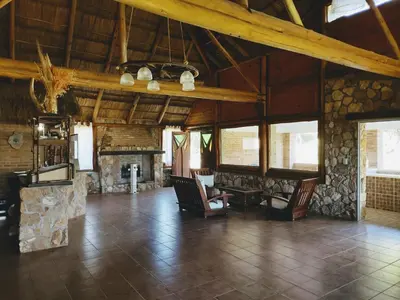 a living room with chairs and a stone fireplace at Apart & Cabañas 