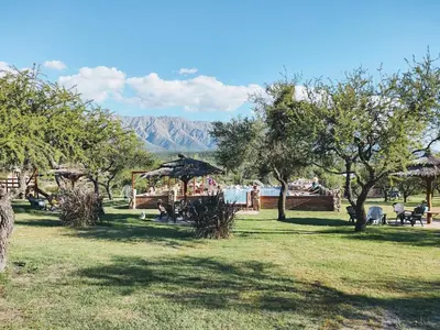 a park with people sitting in the grass at Apart & Cabañas 