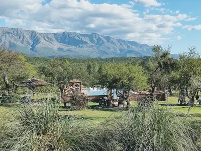 a field with a train and mountains in the background at Apart & Cabañas 