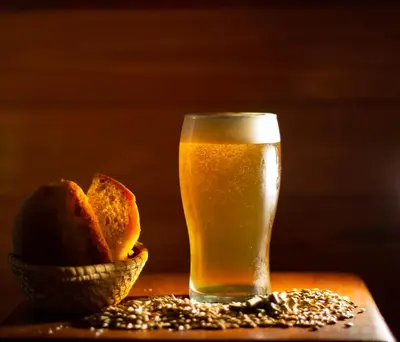 a glass of beer next to a bowl of bread at Hosteria Rural Piedra y Camino in Nono