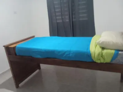 a small bed with a blue blanket on top of it at Piquillin San Lorenzo in San Lorenzo