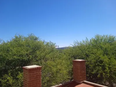 a brick chimney on top of a house with trees at Piquillin San Lorenzo in San Lorenzo