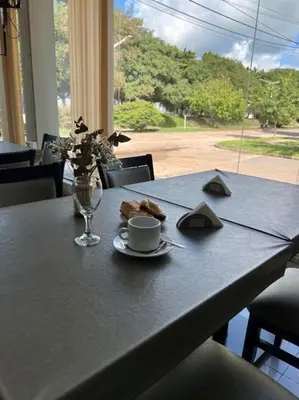 a table with a plate of food and a cup of coffee at Hotel Rincon Del Este in General Deheza