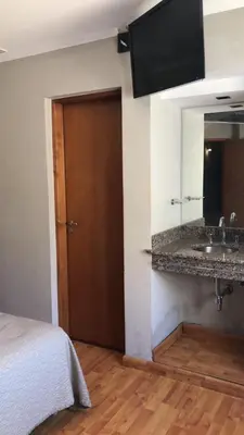 a room with a bed and a sink and a mirror at Hotel Rincon Del Este in General Deheza