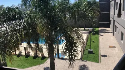 a palm tree in front of a swimming pool at Hotel Rincon Del Este in General Deheza