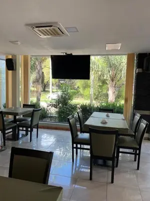 a restaurant with tables and chairs and a large window at Hotel Rincon Del Este in General Deheza