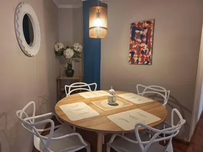 a dining room table with white chairs and a light at La mejor ubicación turística del centro Córdoba in Cordoba