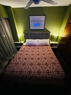 a bedroom with a bed with a red blanket and green walls at Refugio Urbano in Cordoba