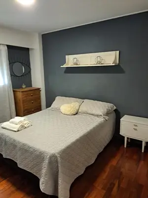 a bedroom with a bed and a shelf on the wall at Departamento -Balcarce- Nueva Córdoba, ByApartcba in Cordoba