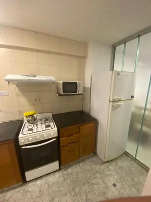 a kitchen with a stove and a white refrigerator at Departamento -Balcarce- Nueva Córdoba, ByApartcba in Cordoba