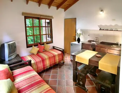 a living room with two beds and a kitchen at Posada La Escondida in Villa General Belgrano