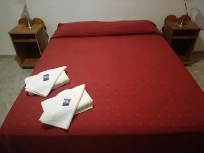 a red bed with white pillows on top of it at White Field Houses and Spa in Villa de Las Rosas