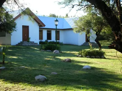 a white house with a tree in the yard at White Field Houses and Spa in Villa de Las Rosas