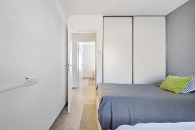a bedroom with white walls and a bed at Familia y Amigos con Pileta, Asador y Cochera in Cordoba