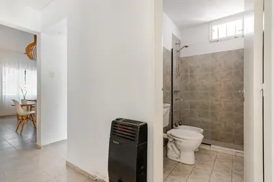 a bathroom with a toilet and a walk in shower at Familia y Amigos con Pileta, Asador y Cochera in Cordoba