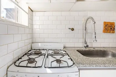 a kitchen with a stove and a sink at Familia y Amigos con Pileta, Asador y Cochera in Cordoba