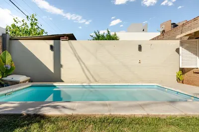 a swimming pool in front of a building at Familia y Amigos con Pileta, Asador y Cochera in Cordoba