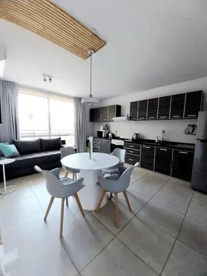 a kitchen and living room with a table and chairs at Depto Etoile 2 ubicación confort y amenities in Villa Carlos Paz